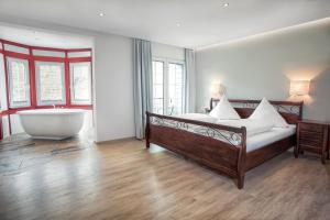a bedroom with a large bed and a bath tub at Hotel Filla Andre in Ernst