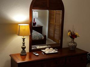 a dressing table with a lamp and a mirror at Sweet Serenity St Croix USVI in Christiansted