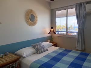 1 dormitorio con cama, ventana y espejo en AllMar Flats - Apartamentos frente mar - Beach Village, en Fortaleza