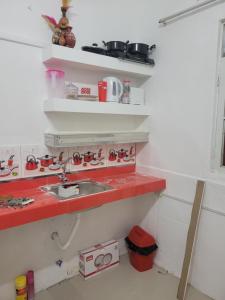 a kitchen with a sink and a red counter top at Amalfi's Place in Pimentel