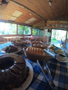 大普拉亞的住宿－Chalé Marrocos com Hidromassagem Pousada Índios Coroados，一张桌子,上面有食物,放在蓝白桌布上