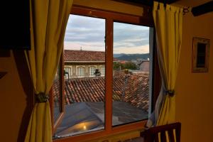 een raam met uitzicht op een dak bij Hotel Posada del Angel in Cuenca