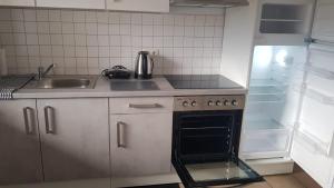 a small kitchen with a stove and a sink at Wohnung am VW-Werk mit Balkon in Kassel