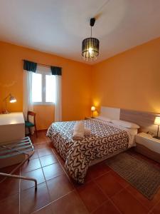 a bedroom with a large bed with orange walls at Neverending Nature León in Tremor de Arriba