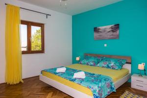 a bedroom with a bed with blue walls and a window at Holiday Home Villa Marija in Radošić +28 photos