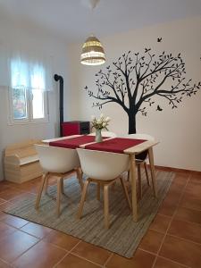 a dining room table with a tree stencil on a wall at Neverending Nature León in Tremor de Arriba