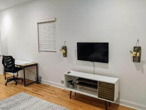 a living room with a tv on a white wall at Cosy Arthington Property in Chicago