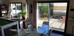 a living room with a glass table and a pool table at Maison 10 pers avec piscine chauffée et spa in Surzur +17 photos