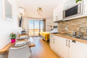 a kitchen and living room with a bed and a sink at Beausoleil Studio Metro Paris Sud in Le Kremlin-Bicêtre