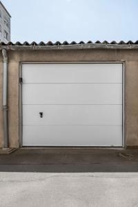 uma porta de garagem branca do lado de um edifício em Bel appartement avec garage sur l'île de Nantes em Nantes