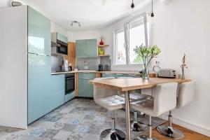 uma cozinha com armários azuis e uma mesa de madeira em Bel appartement avec garage sur l'île de Nantes em Nantes