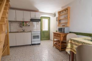 a kitchen with white cabinets and a green door at Rustica in Vrbnik