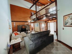 a living room with a leather couch and a table at Casarão do Bosque a 200 m da praia | ROUR218 in Rio das Ostras