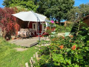 a small house with a white umbrella in a yard at Fuchsbau in Walsrode