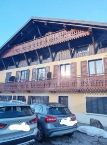 two cars parked in a parking lot in front of a building at Studio du lac bleu in Morillon