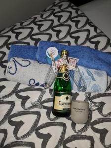 a bottle of champagne and two wine glasses on a bed at Apartman -HARMONY- in Paraćin +42 photos