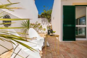 una casa blanca con una puerta verde y una planta en Cozy and sunny villa just some steps from the sea, en Luz