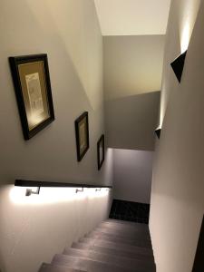 un pasillo con una escalera con dos cuadros en la pared en W-8 - Moderne Ferienwohnung mit viel Charme & spektakulärem Blick en Sandebeck
