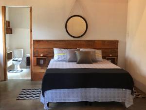 a bedroom with a large bed with a mirror on the wall at Pousada Chalés da Lua in Munhoz