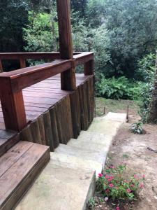 a wooden deck with a bench and some flowers at Pousada Chalés da Lua in Munhoz