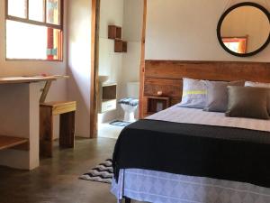 a bedroom with a bed and a mirror on the wall at Pousada Chalés da Lua in Munhoz