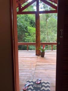 an open door to a deck with a potted plant at Pousada Chalés da Lua in Munhoz