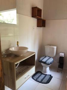 a bathroom with a sink and a toilet at Pousada Chalés da Lua in Munhoz