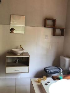 a bathroom with a sink and a mirror at Pousada Chalés da Lua in Munhoz