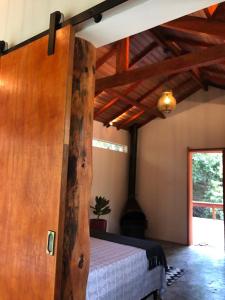 a bedroom with a bed in a room with wooden ceilings at Pousada Chalés da Lua in Munhoz