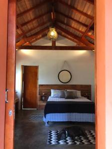 a bedroom with a bed with a dog laying on the floor at Pousada Chalés da Lua in Munhoz