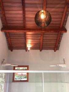 a room with a wooden ceiling and two lights at Pousada Chalés da Lua in Munhoz