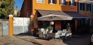 une table et des chaises avec un parasol en face d'un bâtiment dans l'établissement Borgo Portello, à Padoue