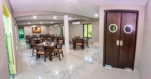 - un restaurant avec des tables, des chaises et une porte en bois dans l'établissement Hotel EL MILAGRO, à El Fuerte