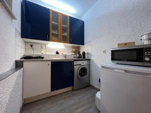 a kitchen with blue cabinets and a washing machine at Einzigartiges Apartment in toller Altstadt by Rabe - free Netflix & Coffee-Bar in Karlsruhe
