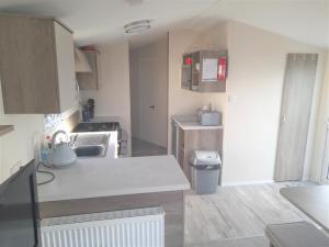 una pequeña cocina con fregadero y encimera en 3 Bedroom Modern Caravan Sleeps up to 8, en Millom