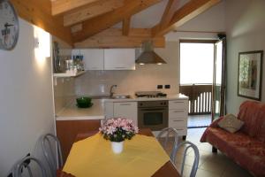 a kitchen with a table with a vase of flowers on it at Casa Ornella in Ledro