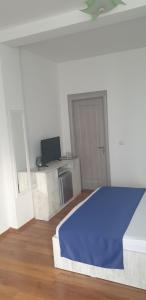 a bedroom with a blue bed and a television at Hotel Allegro in Eforie Nord