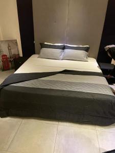 un grande letto con piumone bianco e nero di AlanVal Suites a Accra