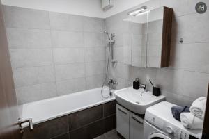 a bathroom with a sink and a bath tub and a washing machine at AH Mlynská Bašta II Free Parking in Košice +42 photos