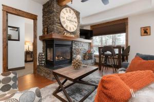 ein Wohnzimmer mit einem Kamin und einer Uhr an der Wand in der Unterkunft Heavenly Mountain Hideaway, Pool, Hot Tub in Radium Hot Springs