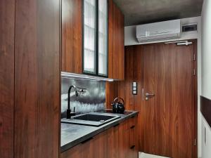 a kitchen with a sink and wooden cabinets at Paderewskiego 9 Aparth in Leszno