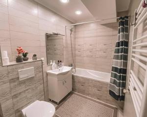 Un baño con inodoro, lavabo y bañera. en Sweet Home Apartment, en Chişinău