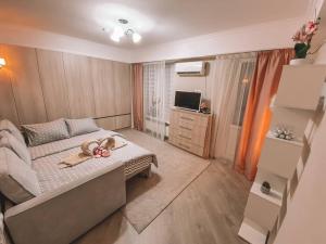 Una pequeña habitación con una cama y un televisor. en Sweet Home Apartment, en Chişinău 6 fotos más