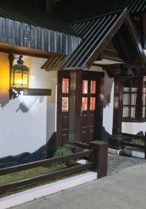 ein Haus mit einer Holztür und einer Lampe in der Unterkunft FLOR AUSTRAL in Ushuaia