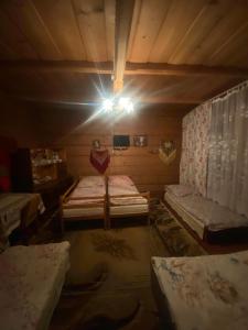 a room with two beds and a light on the ceiling at Góralskie Pokoje in Witów