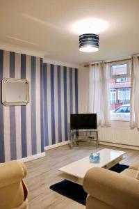 a living room with a couch and a table at Entire Family Vacation Home . WiFi . FREE Parking in Beeston