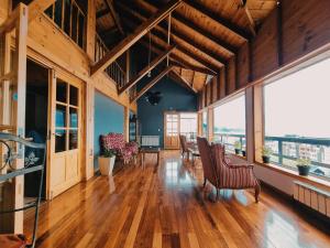 a large living room with wooden floors and large windows at FLOR AUSTRAL in Ushuaia