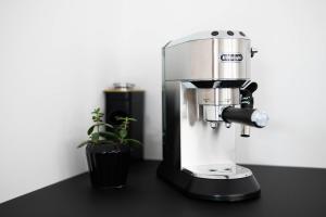 a coffee maker sitting on a counter next to a plant at Luxuriöses Apartment, 10min Innenstadt, Parkplatz in Erfurt