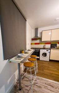 a kitchen with a table and stools in a room at Beautiful Apartment - up to 4 guests - Leicester City Centre . Free WIFI in Leicester