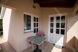 a patio with two pink chairs and a table at House Maca in Palit